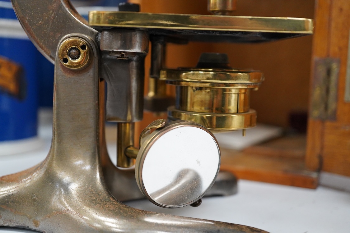 An early 20th century oak cased brass ‘Kima’ microscope by W. Watson & Sons Ltd. London, with engraved serial number under the maker’s name; 53622, with two alternative lenses in fitted compartments, microscope approxima